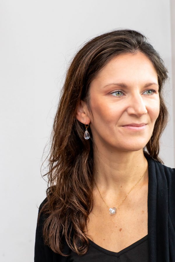 Une photo portée avec les boucles d'oreilles en verre de Murano transparentes incolores faites à la main par la créatrice Diatomée dans son atelier boutique à Paris 14