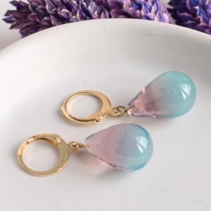 Des boucles d'oreilles en verre de Murano bicolores prune et menthe glacée faites à la main par la créatrice Diatomée dans son atelier boutique à Paris 14