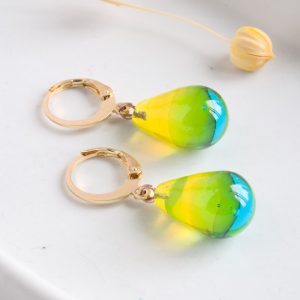 Des boucles d'oreilles en verre de Murano bicolores jaune et bleu glacée faites à la main par la créatrice Diatomée dans son atelier boutique à Paris 14