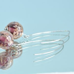 Boucles d'oreilles en verre de Murano prune et aventurine fabriquées par une artisan verrier à Paris.